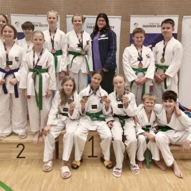 zawodnicy taekwondo pozujący do grupowego zdjęcia